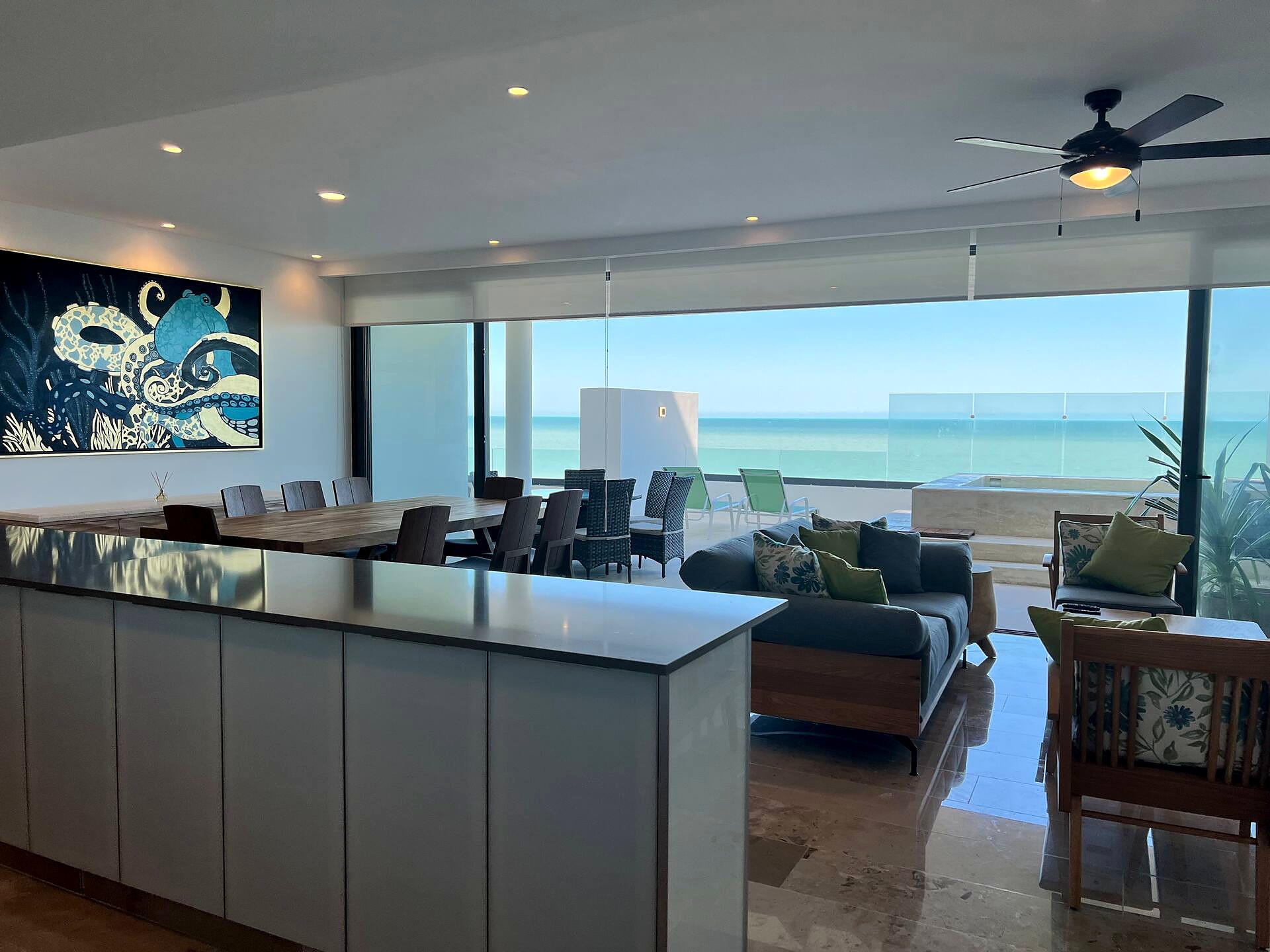 Gran salón del penthouse Ballena con ventanales de piso a techo al mar