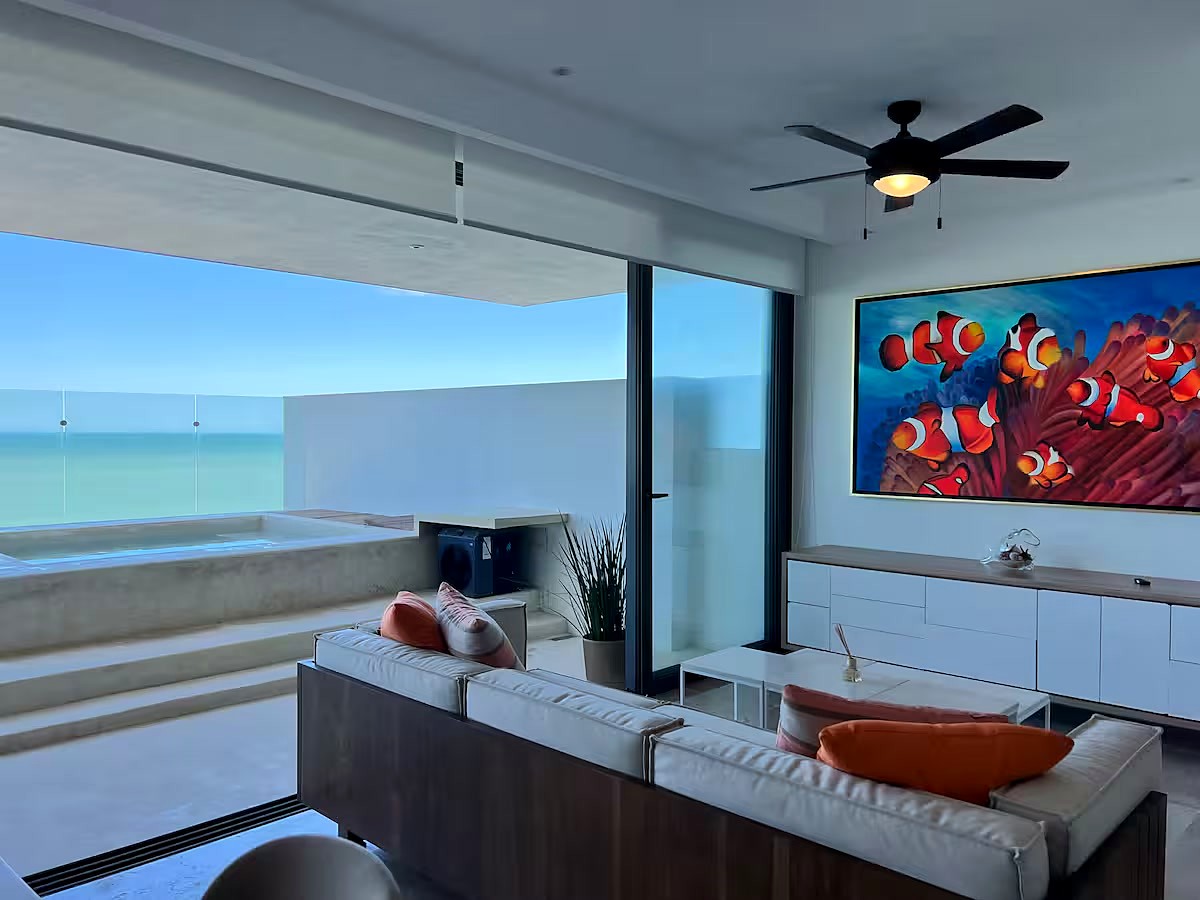 Sala del penthouse Coral con arte de peces payaso y terraza con alberca